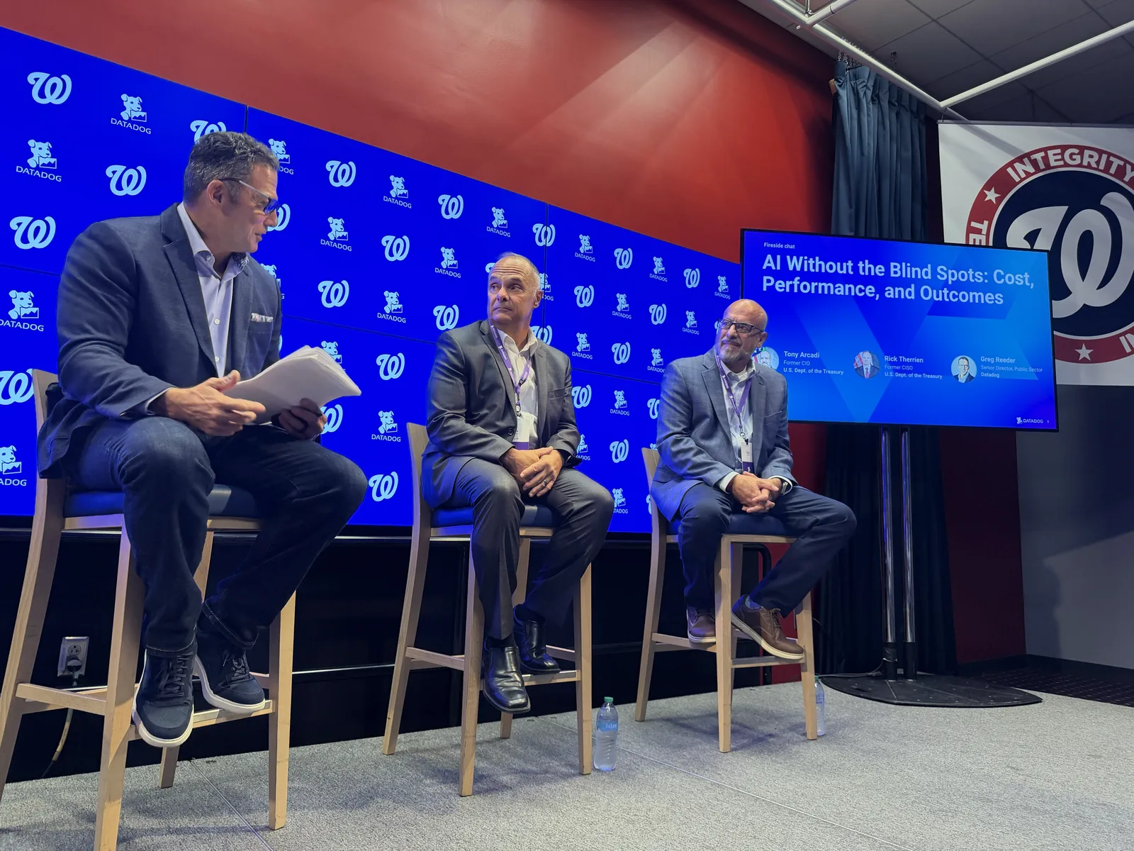 Panel discussion at Datadog’s Federal AI Forum, with the screen showing AI Without the Blind Spots: Cost, Performance, and Outcomes